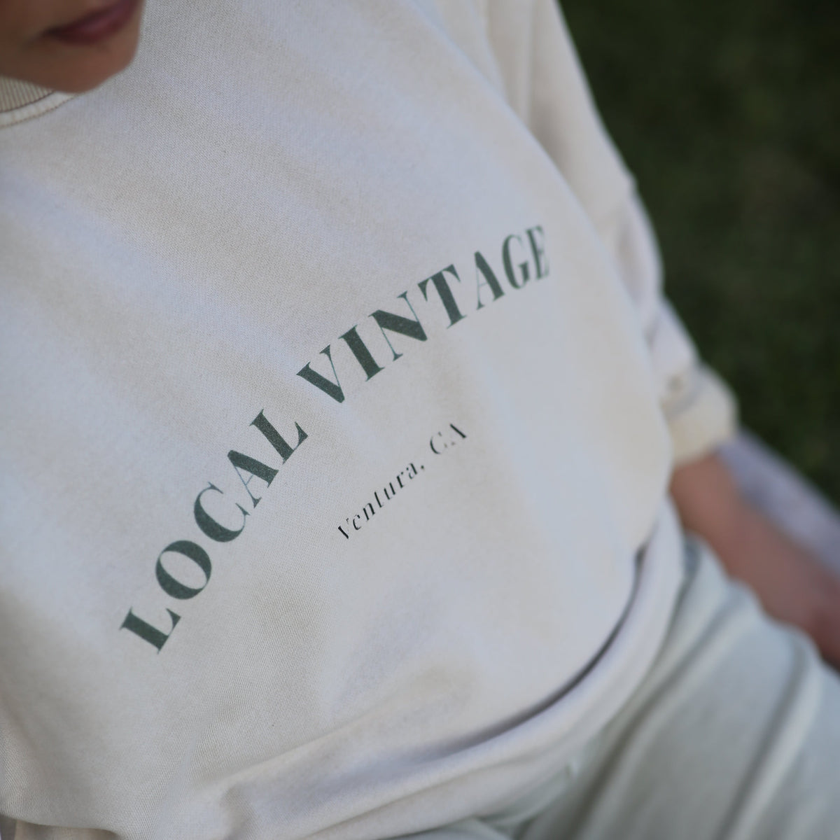 White sweatshirt with 'LOCAL VINTAGE' text on a person wearing it.