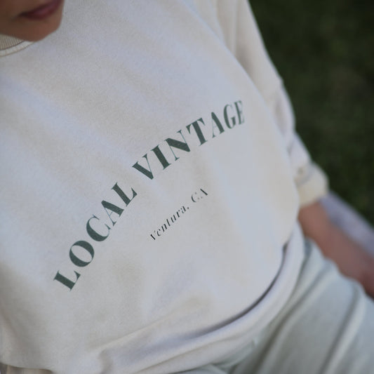 White sweatshirt with 'LOCAL VINTAGE' text on a person wearing it.